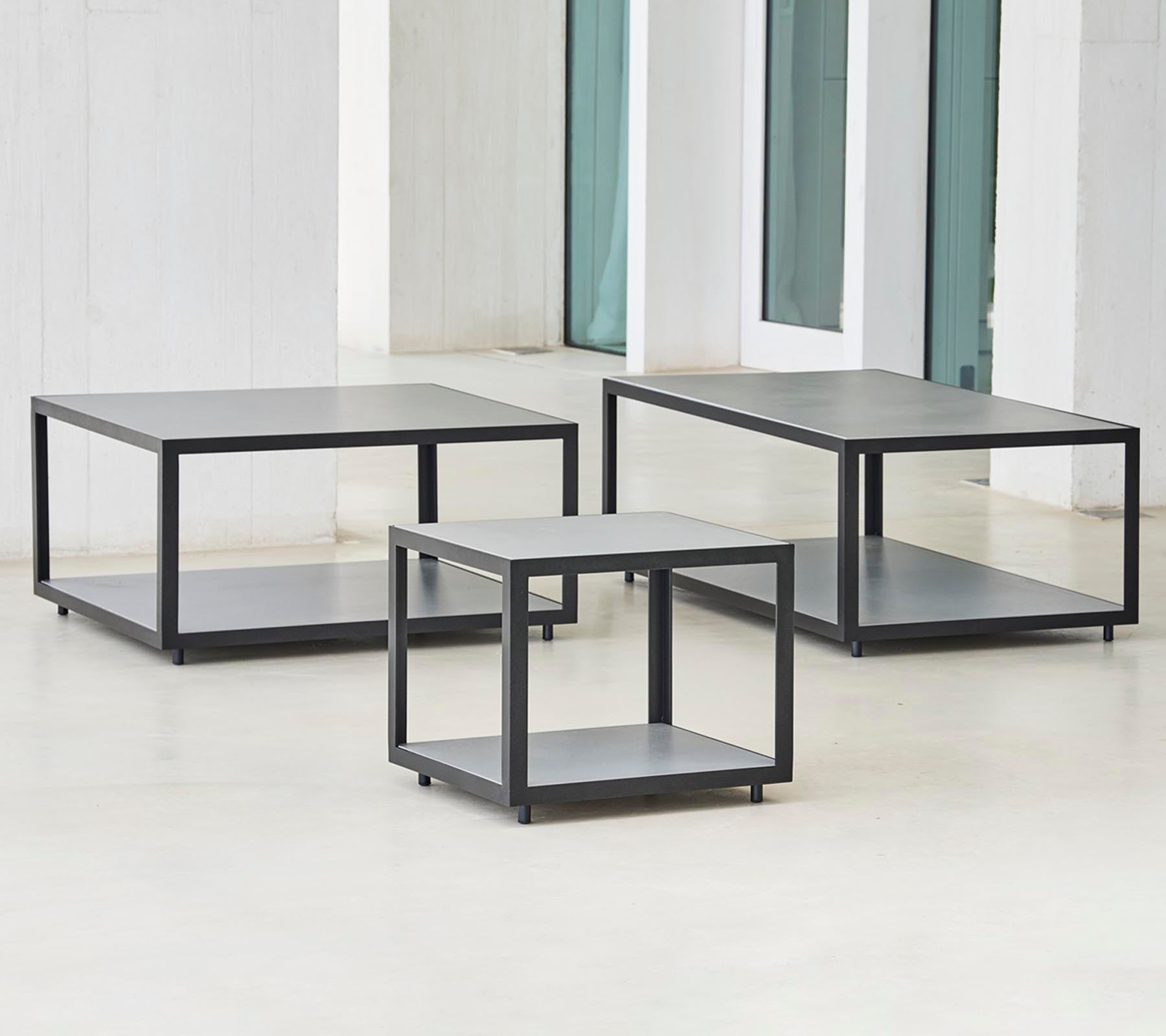 Trois tables modernes au design minimaliste, dotées d'un cadre élégant et de plusieurs niveaux pour le rangement ou l'affichage.