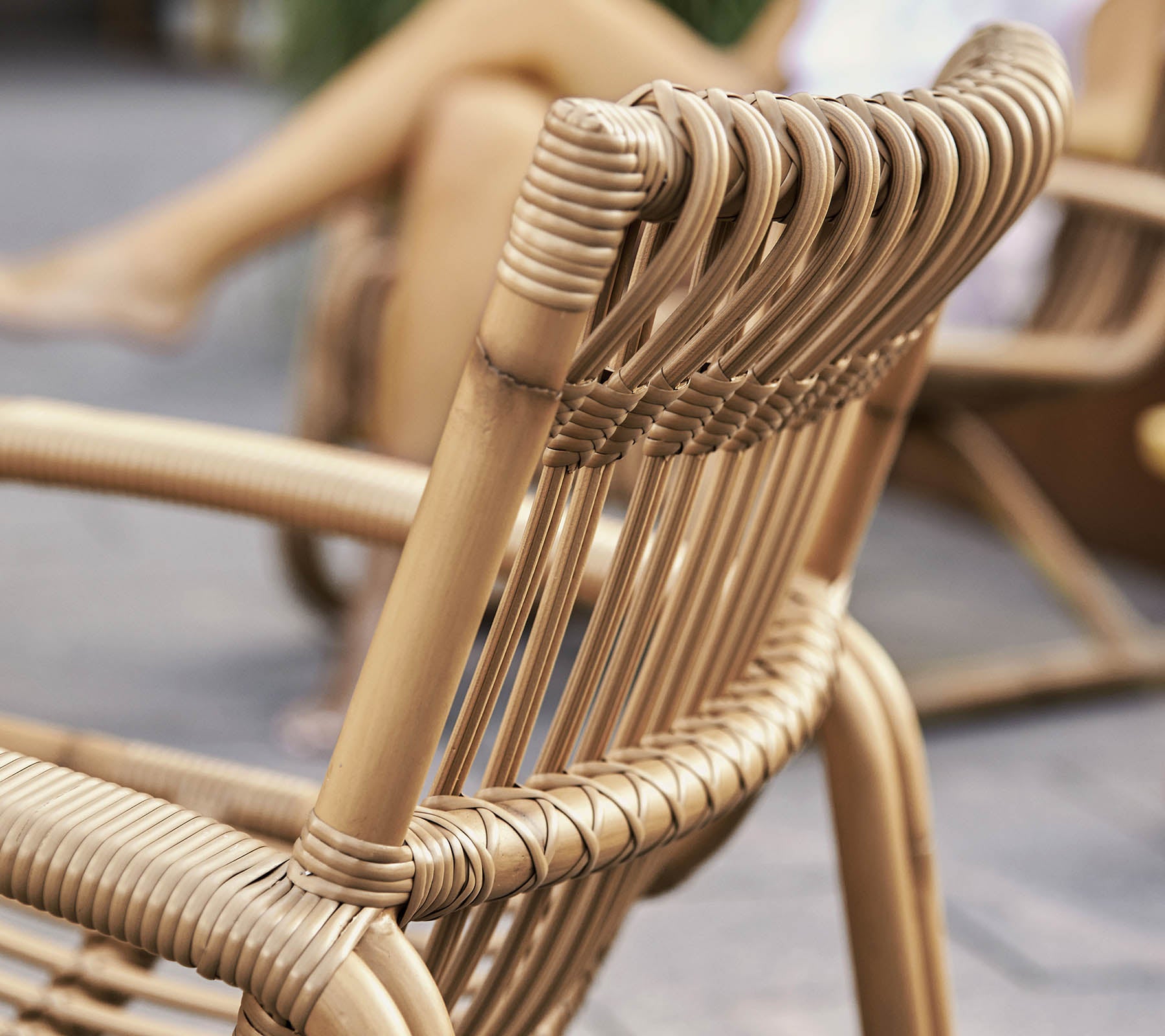 Vue en gros plan d'une chaise tissée élégante au design moderne, mettant en valeur un savoir-faire détaillé et des matériaux naturels.