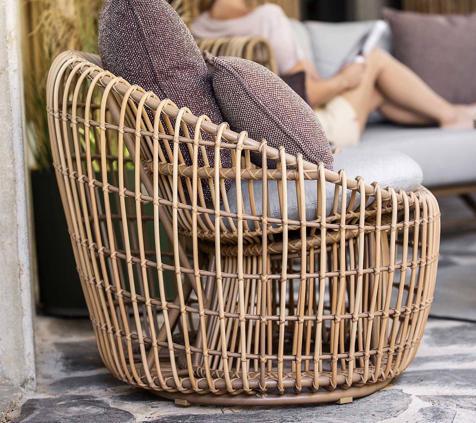 Une chaise tissée chic au design ouvert, dotée de deux coussins moelleux pour plus de confort. Parfaite pour une assise décontractée.