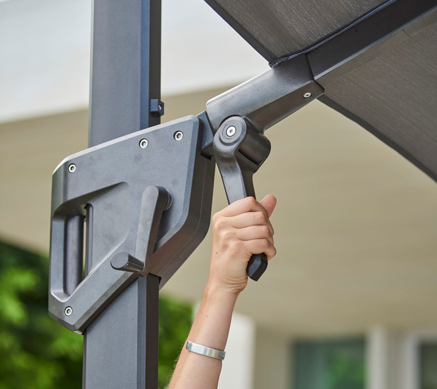 Ajustement manuel d'un mécanisme d'ombrage, mettant en avant un design épuré pour un contrôle optimal de la lumière et une commodité.