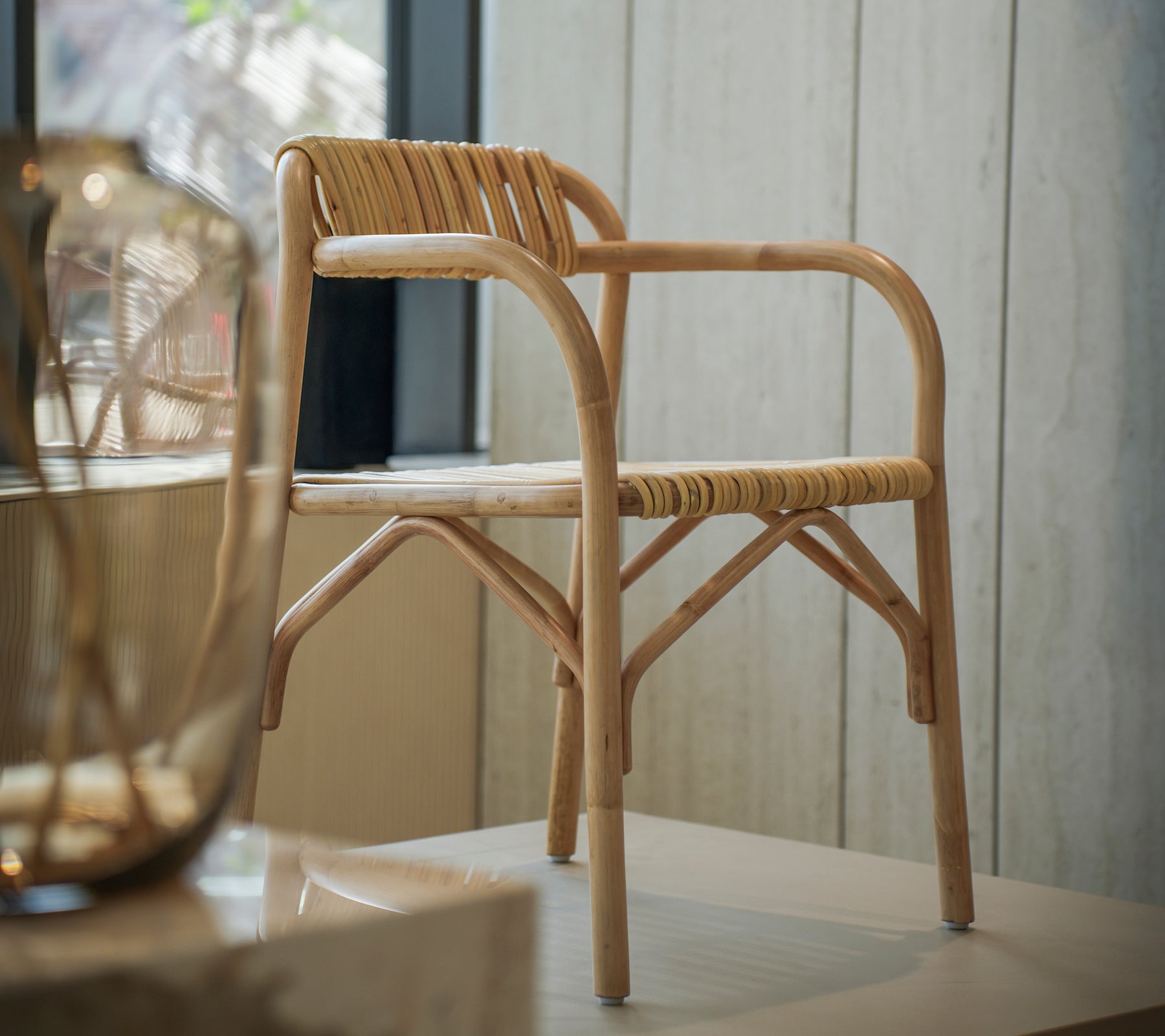 Chaise en bambou moderne avec un siège tissé dans un espace intérieur lumineux.