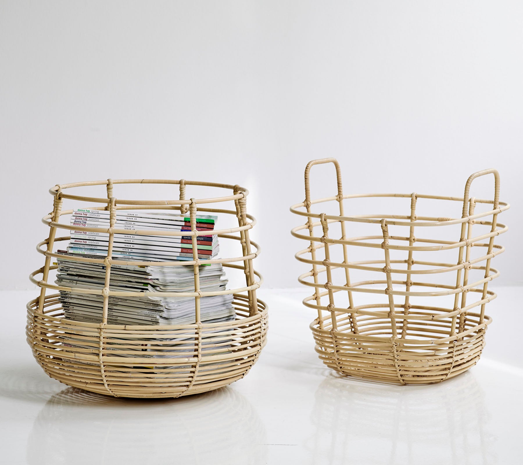 Deux paniers de rangement tissés, un plus grand et rond avec des papiers à l'intérieur, et un plus petit, de conception ouverte à côté, les deux dans une couleur naturelle.
