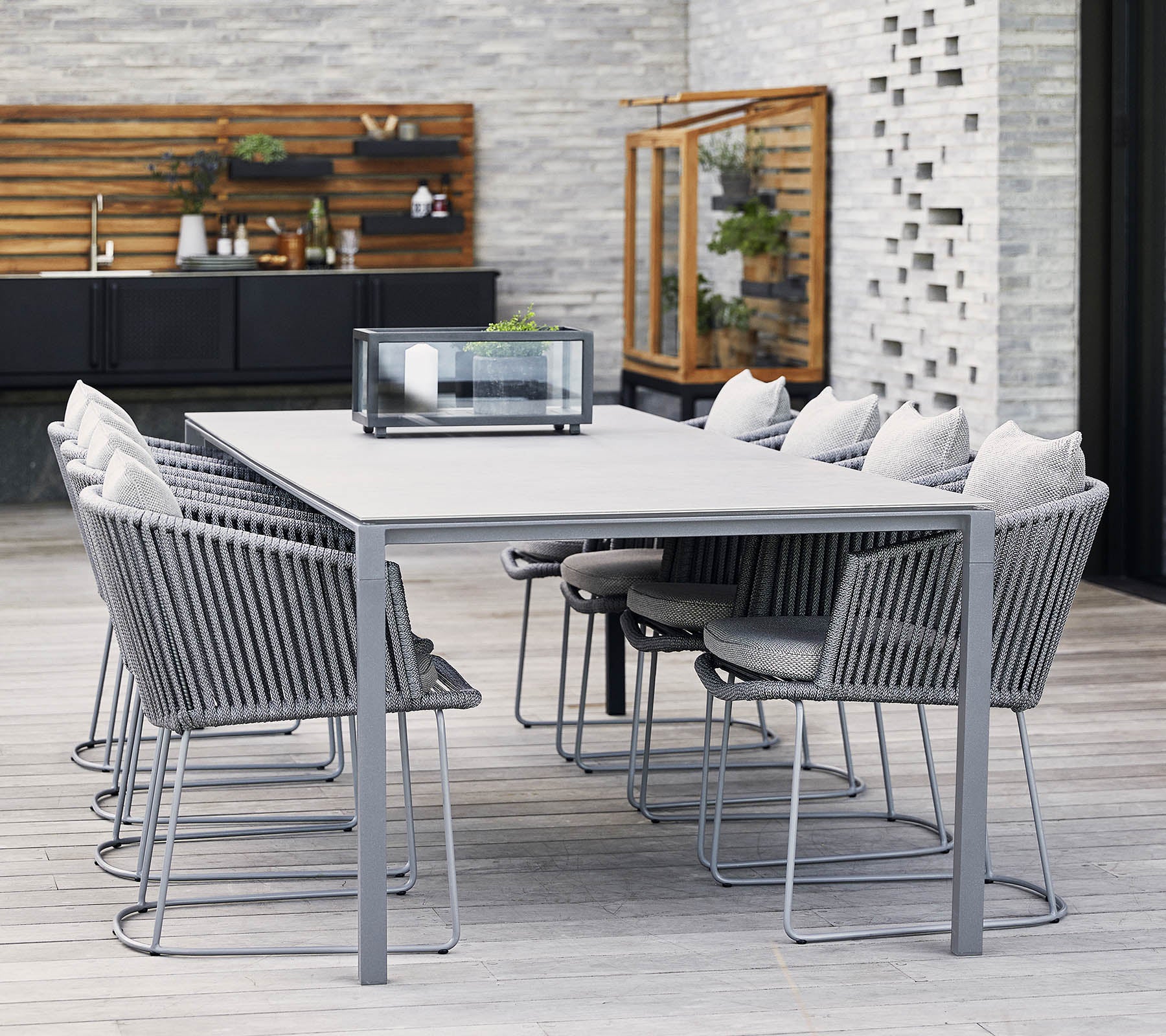 Une table à manger moderne avec un cadre en métal gris et des chaises confortables, dotée de coussins doux et d'un design minimaliste, parfaite pour les réunions.