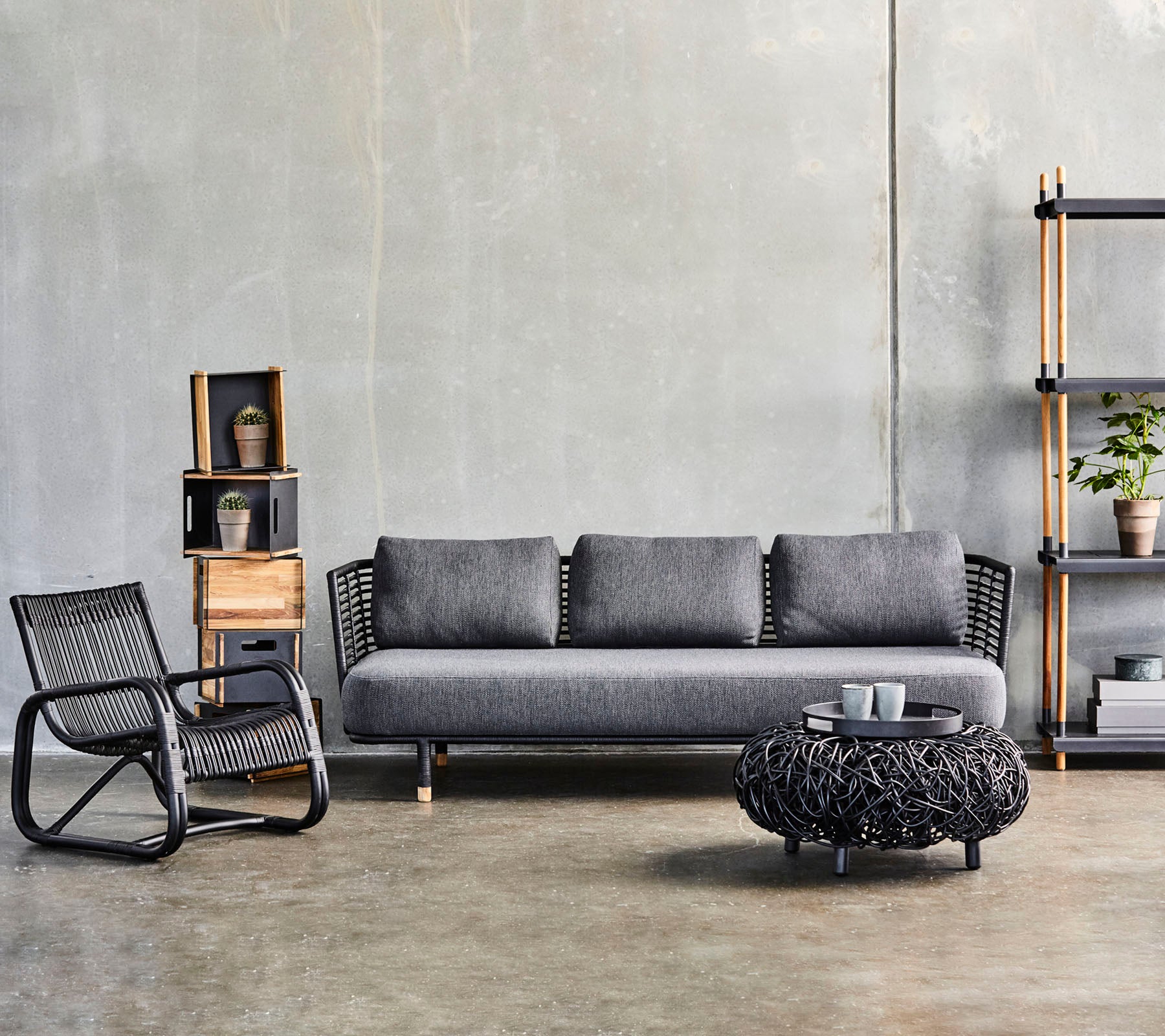 Aménagement moderne du salon avec un canapé élégant, une table basse texturée et une chaise d'appoint stylée, complété par des étagères décoratives.