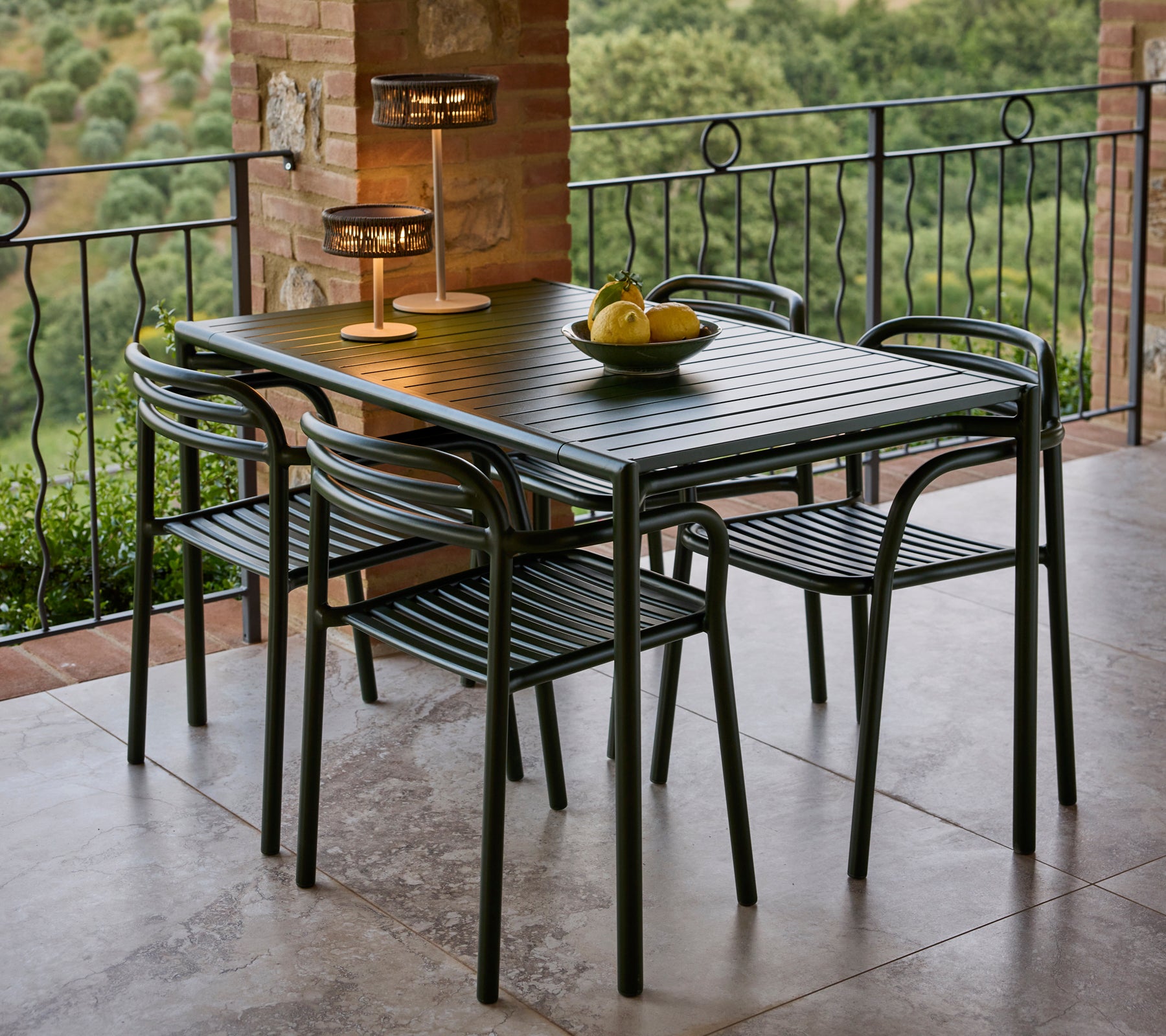 Un ensemble de salle à manger élégant comprenant une table chic, quatre chaises et une lampe élégante, complété par un bol à fruits décoratif.