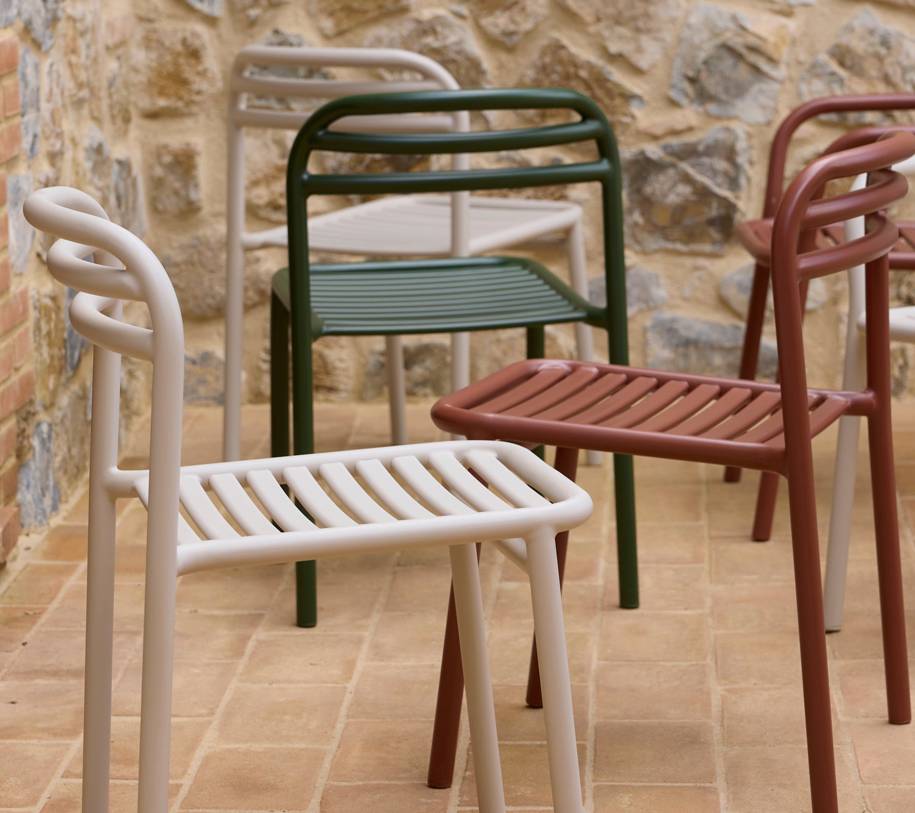 Chaises Bliss affichées en différentes couleurs, avec un design moderne, un siège à lamelles et des accoudoirs courbés.