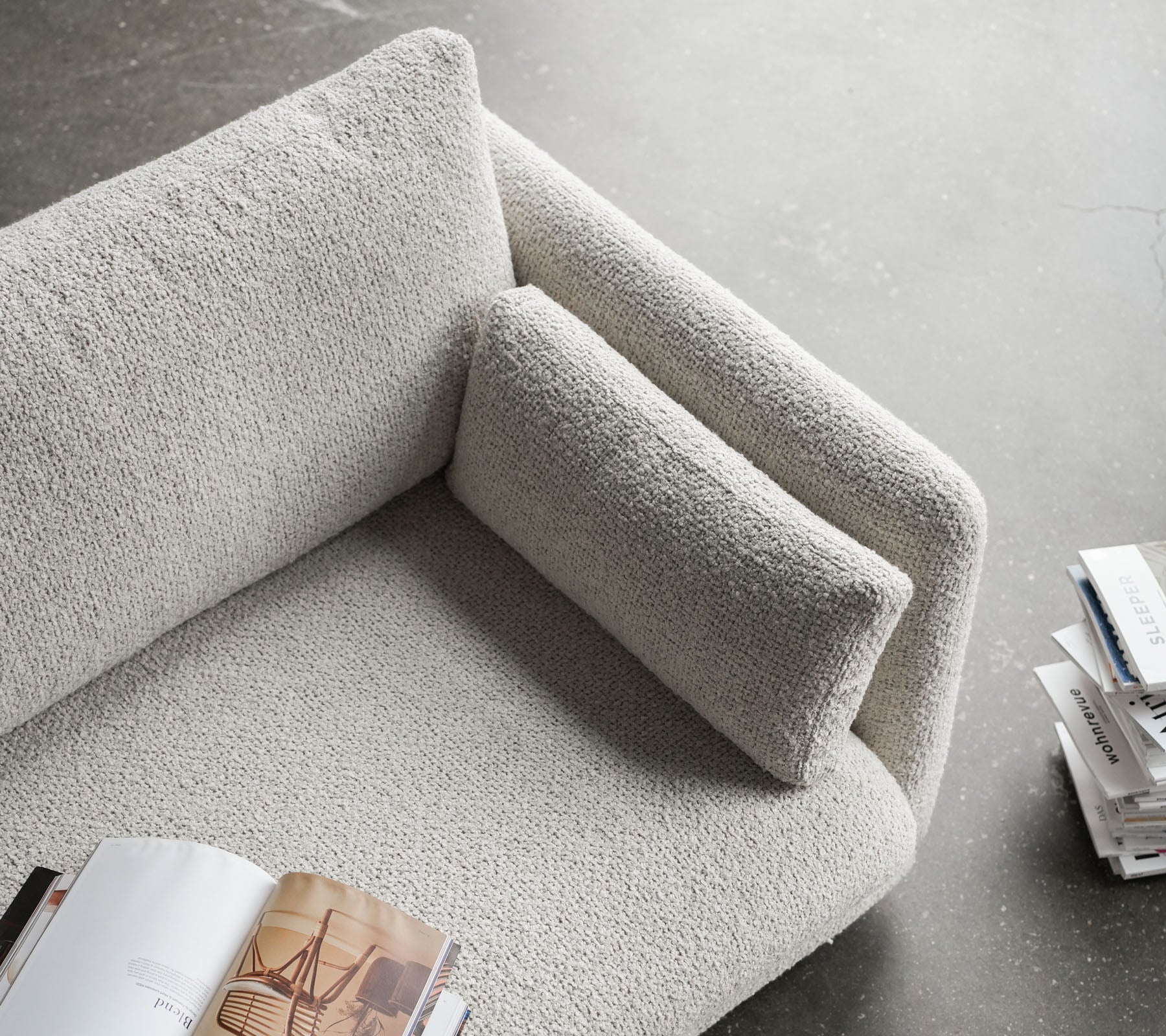 Canapé élégant avec une surface texturée, doté d'un accoudoir moelleux et d'un coussin confortable, parfait pour se détendre et lire.