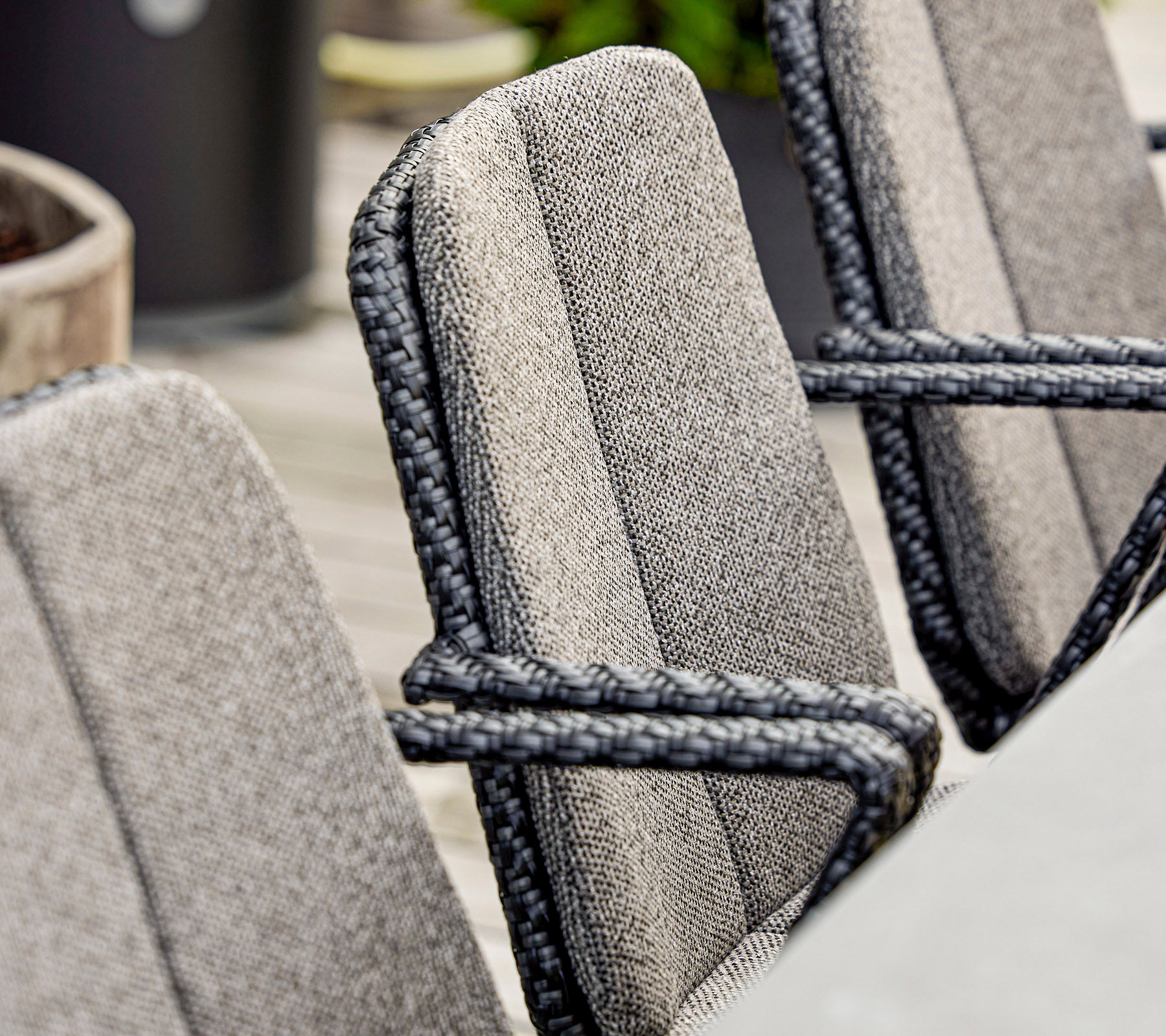 Gros plan de chaises stylées avec un tissu texturé et des détails en corde élégants, adaptées pour un environnement extérieur moderne.