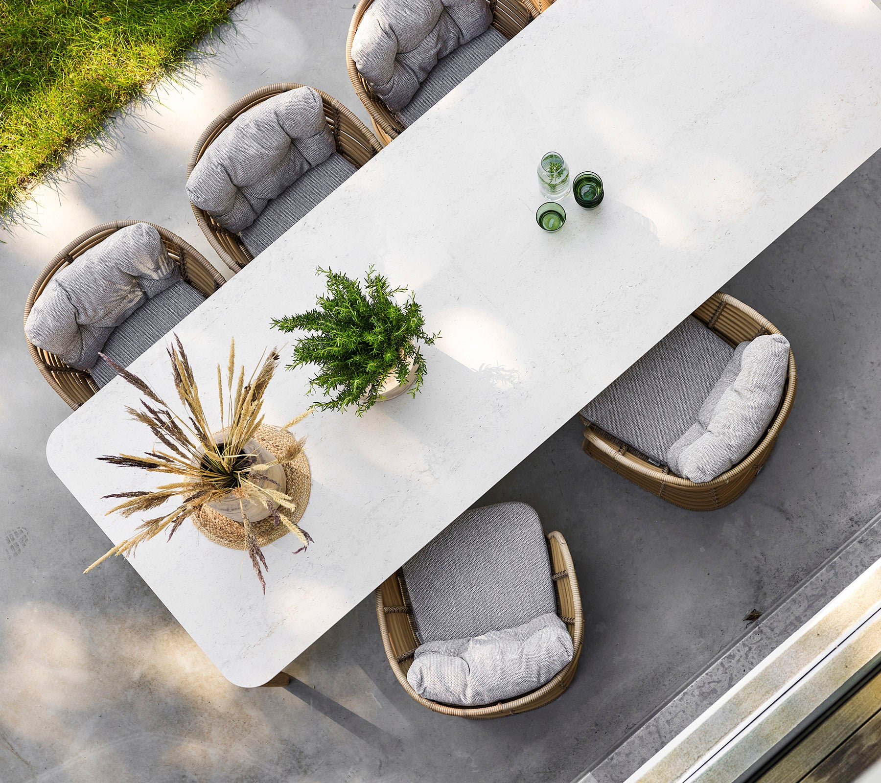 Une table rectangulaire élégante entourée de quatre chaises confortables, ornée de verdure et d'éléments décoratifs sur le dessus.