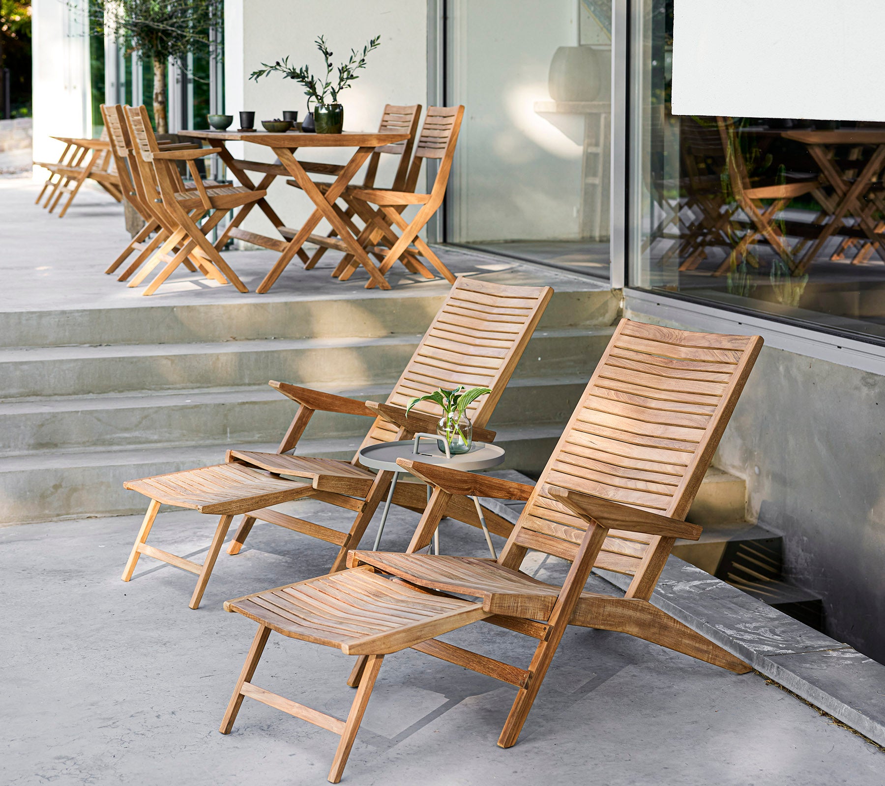 Ensemble de meubles en bois élégant comprenant des chaises longues, une table d'appoint et une table à manger, parfait pour des rassemblements conviviaux et la détente.