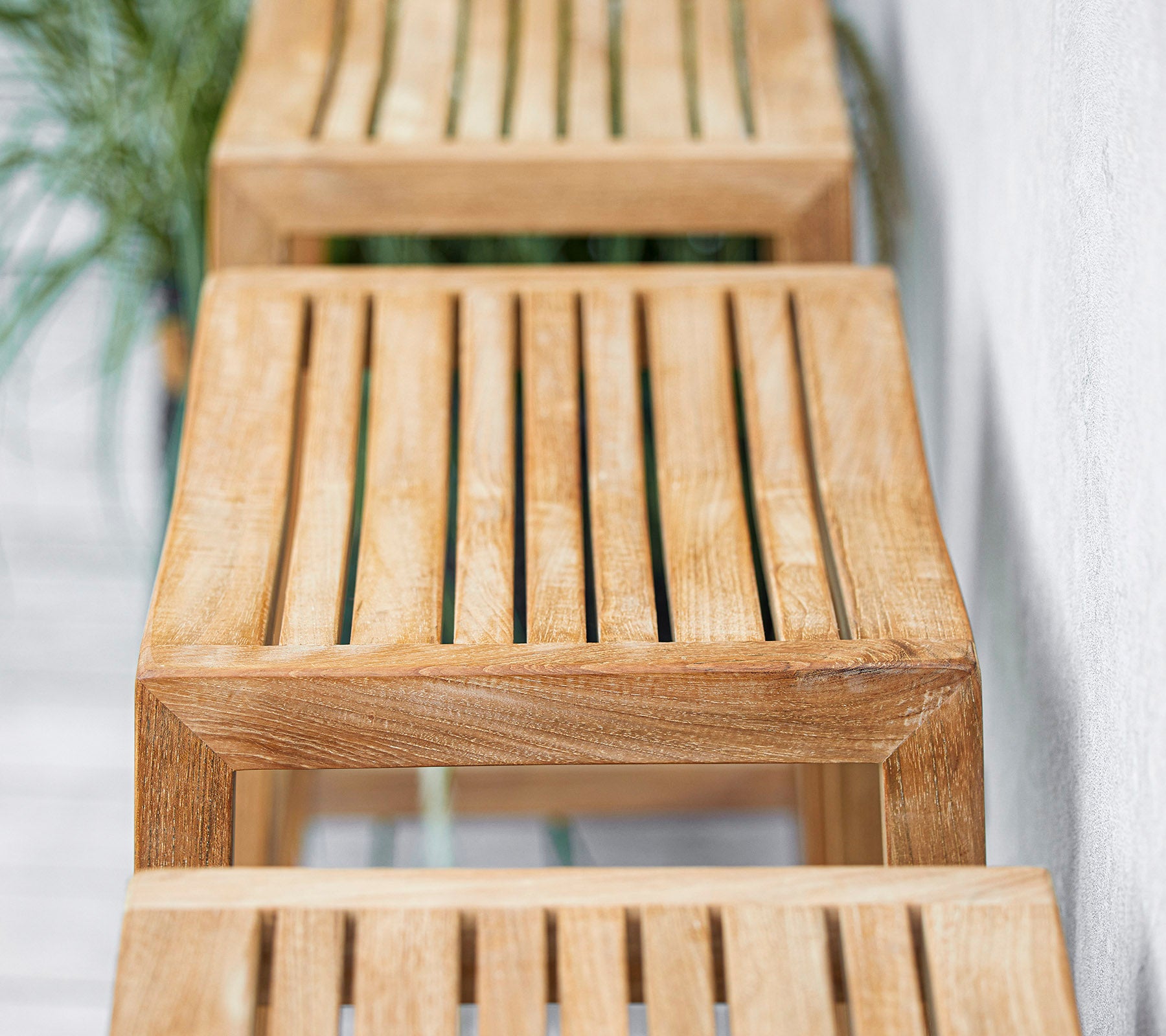Bancs en bois à lattes disposés en rangée avec un design minimaliste, mettant en valeur des textures et des finitions naturelles. Convient à divers environnements.