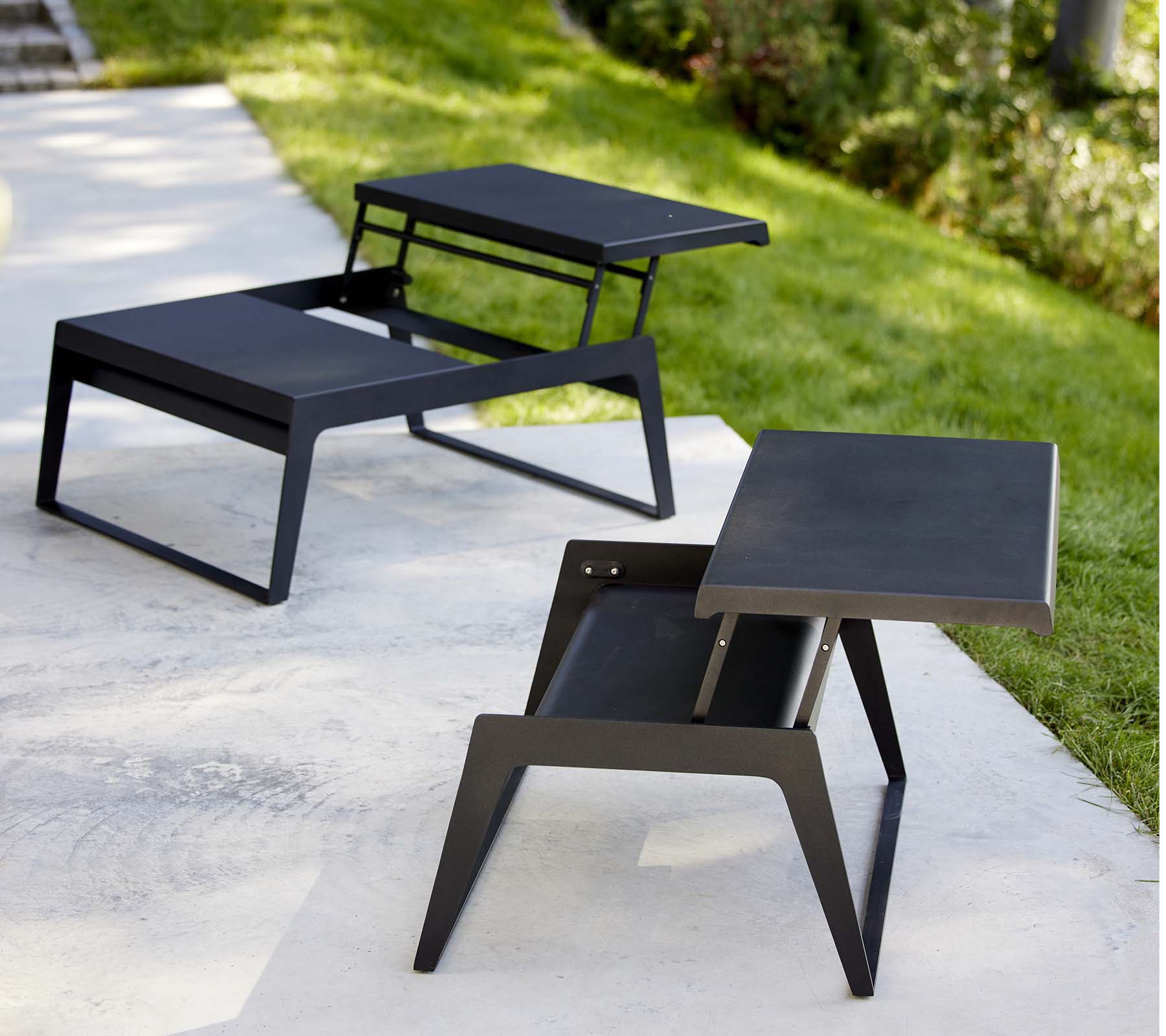 Deux tables basses modernes de détente avec des designs épurés et des finitions noires minimalistes, montrant une polyvalence dans le style et la fonctionnalité.