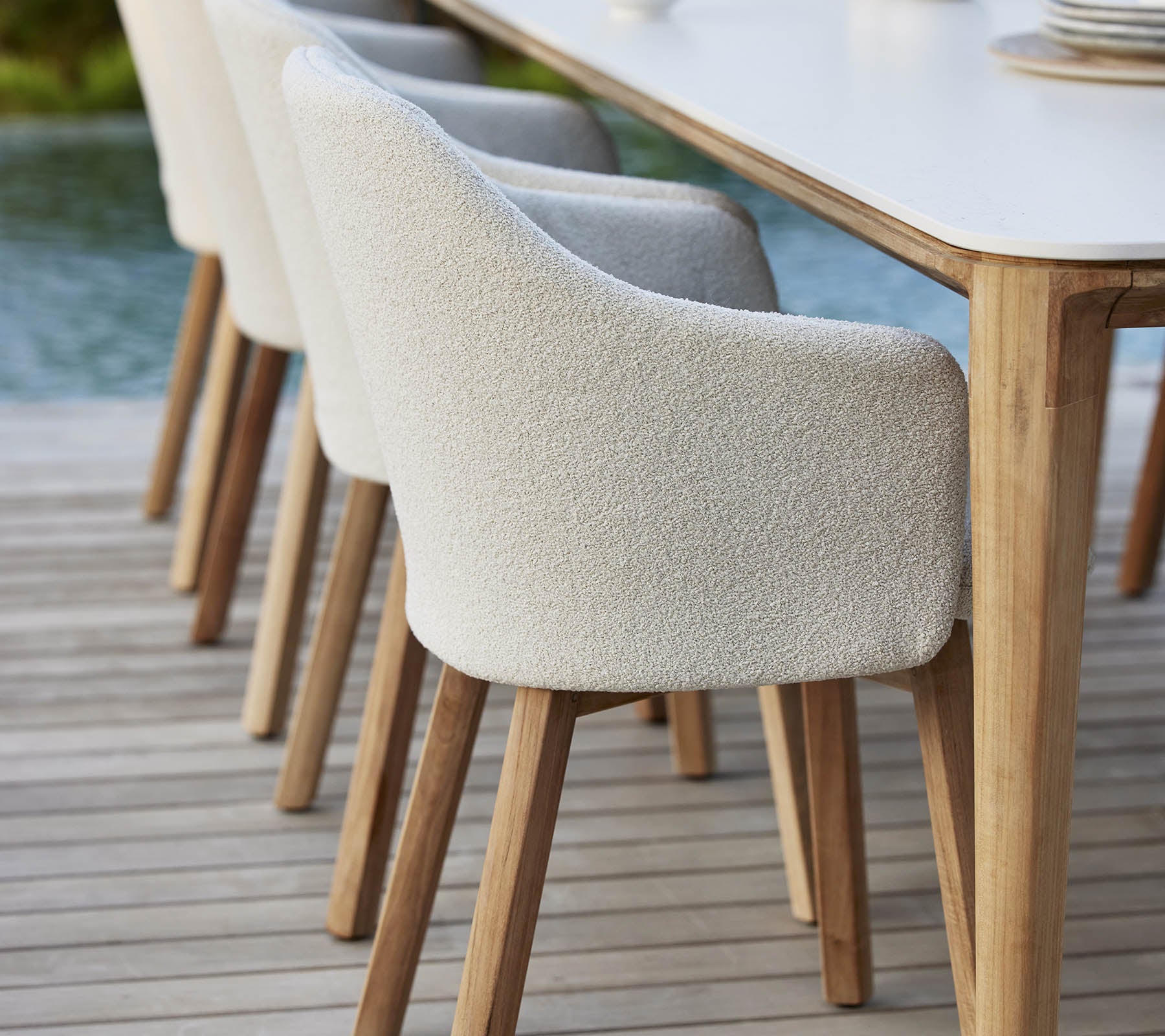 Des chaises rembourrées élégantes avec des pieds en bois sont alignées à côté d'une table, offrant un look moderne et accueillant pour des repas ou des rassemblements.