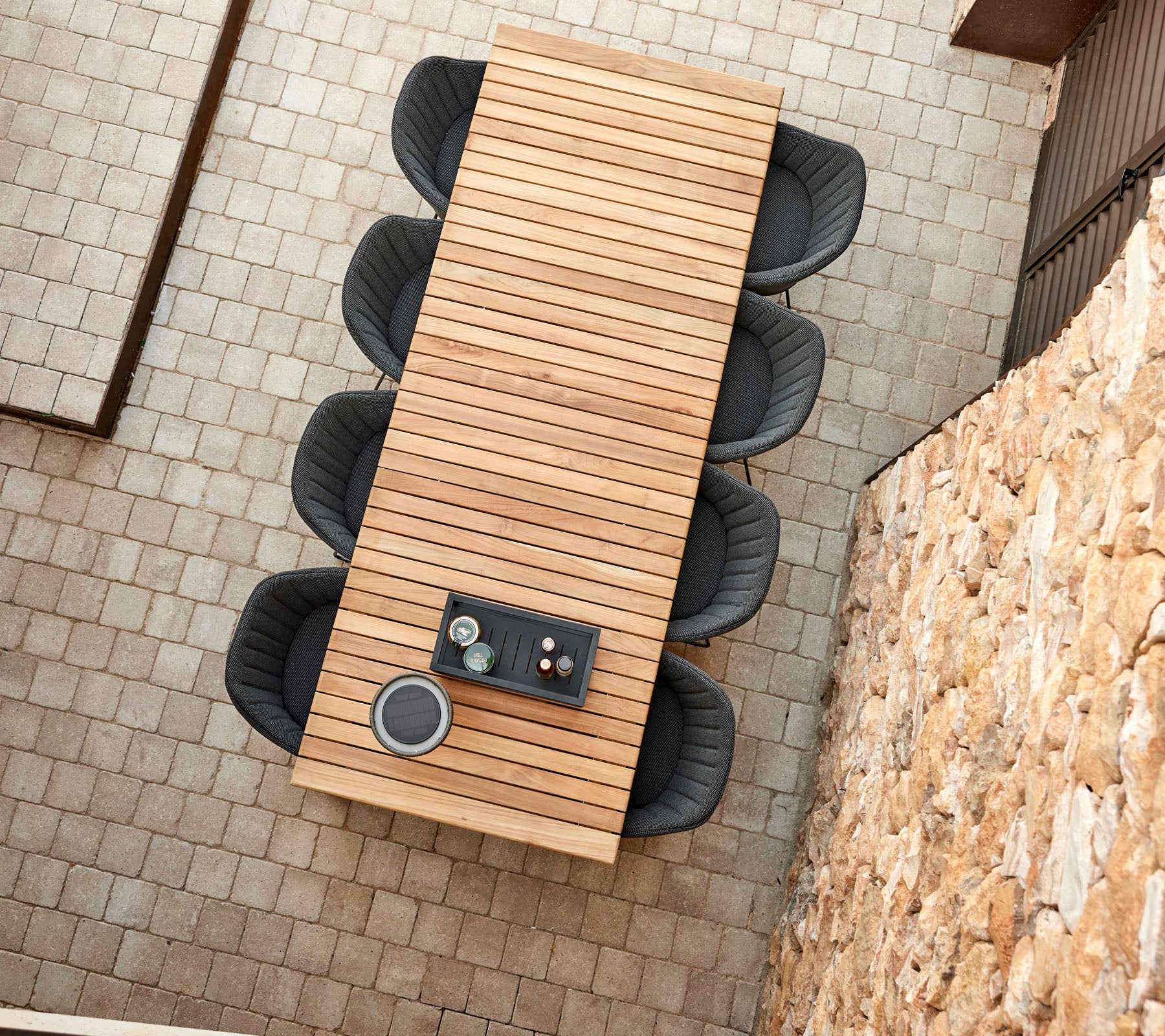 Une longue table en bois avec un design épuré, entourée de quatre chaises modernes, avec une pièce maîtresse décorative.