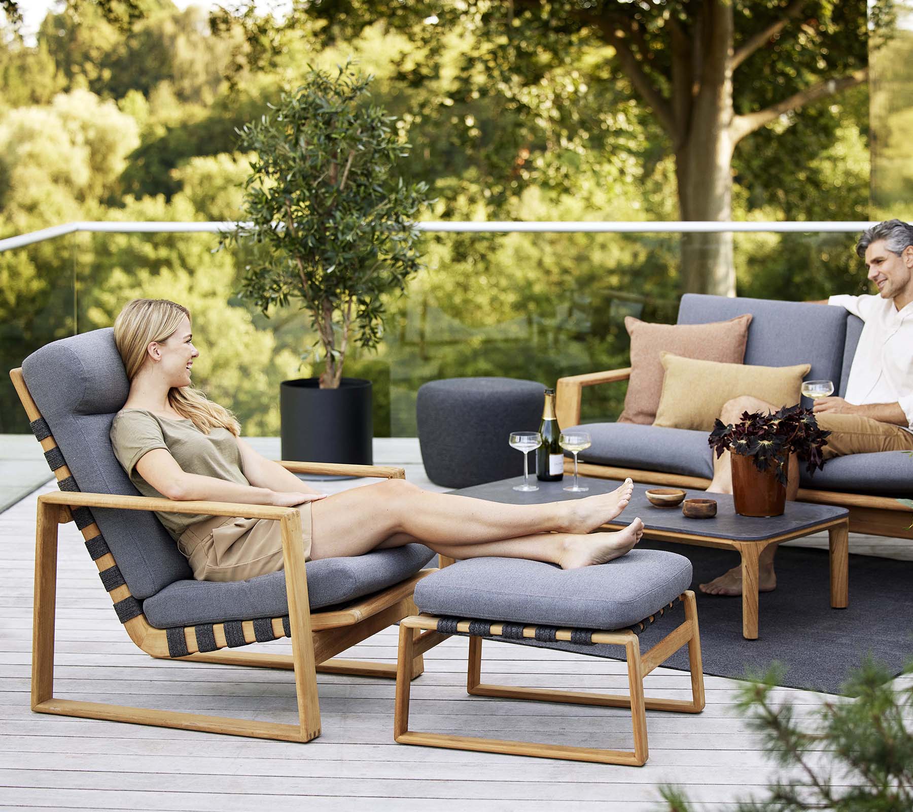 Scène relaxante avec une chaise haute et un canapé assorti, complétés par des coussins décoratifs et une petite table.