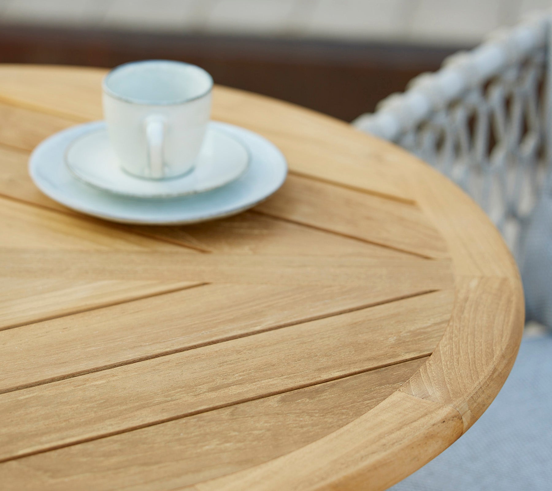Une table en bois avec une tasse à café et sa soucoupe dessus, mettant en avant un cadre de café minimaliste et accueillant.