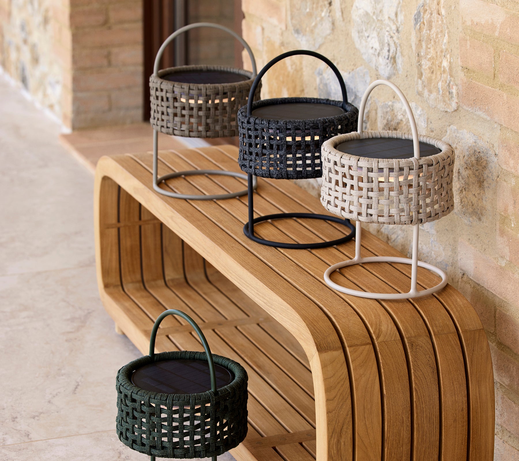 Un agencement élégant de quatre lampes à illusion dans diverses couleurs sur une surface en bois lisse, mettant en avant un design moderne et de l'élégance.