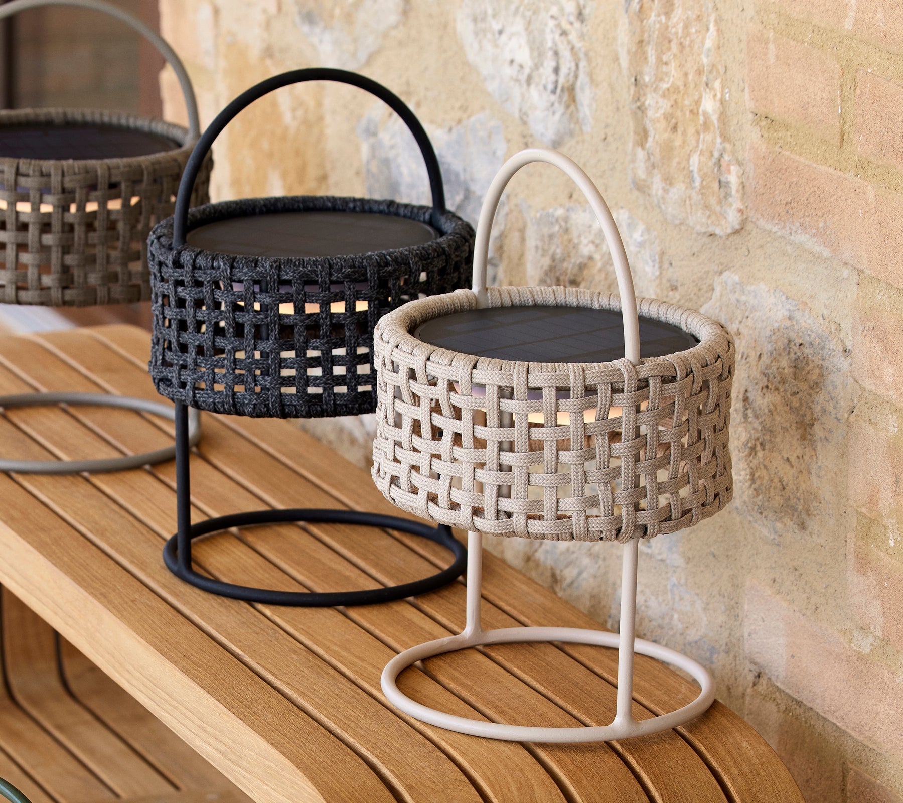 Deux lampes décoratives d'illusion en couleurs sable et noir avec des motifs tissés, placées sur une surface en bois.