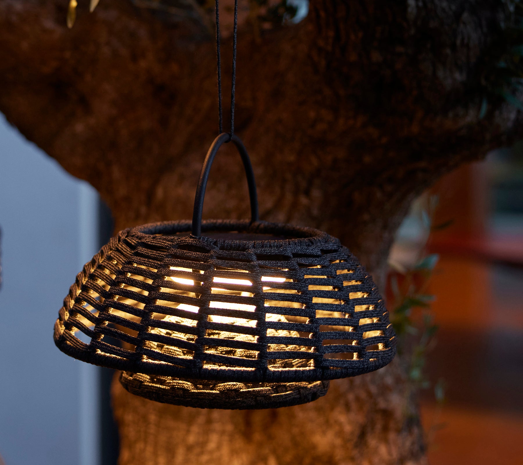 Lampe d'illusion suspendue avec un design tissé complexe et une lumière LED chaleureuse, créant une ambiance accueillante.