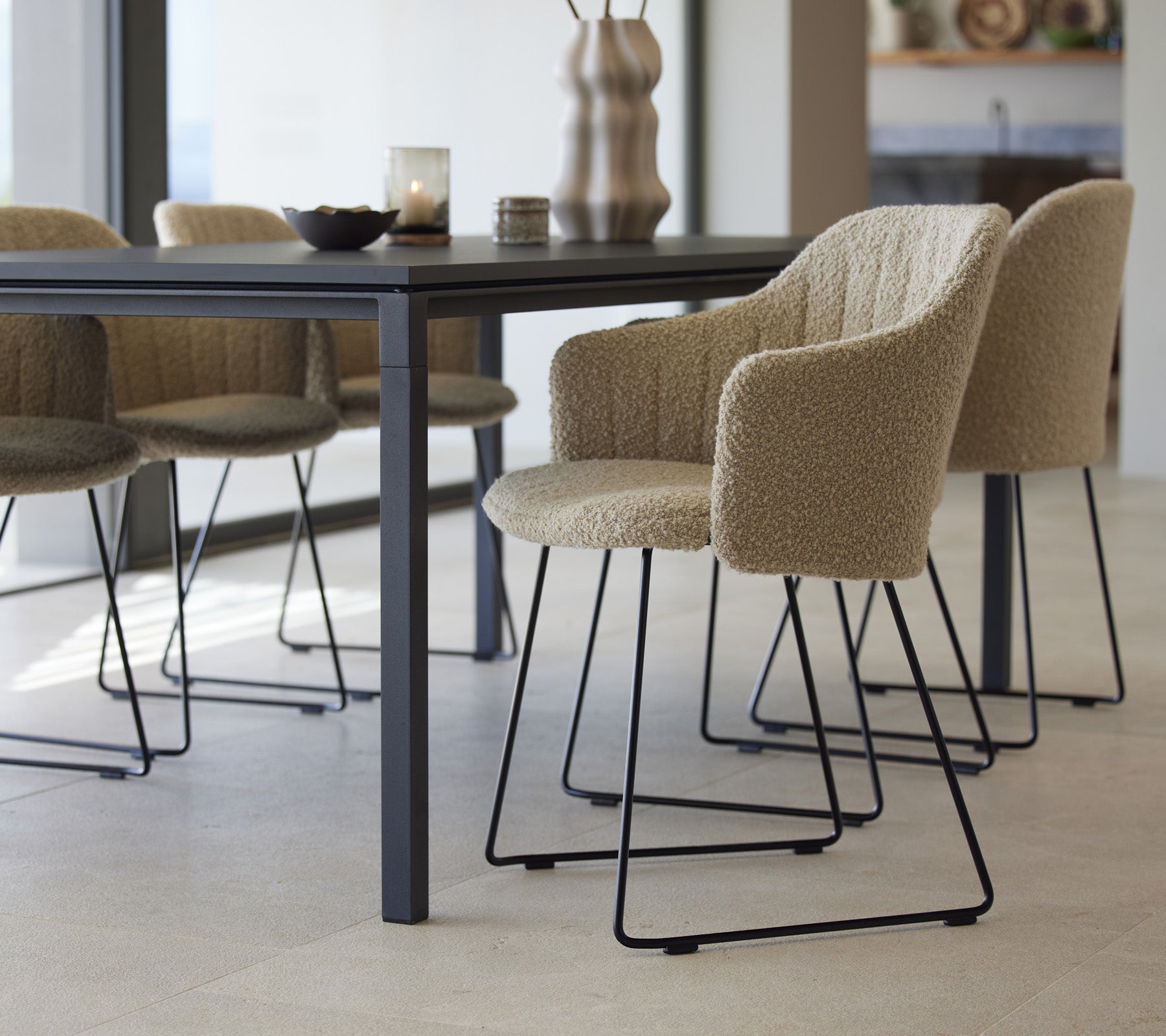 Une table à manger élégante avec des chaises texturées, présentant un design moderne et des éléments minimalistes, prête pour une expérience de dîner accueillante.