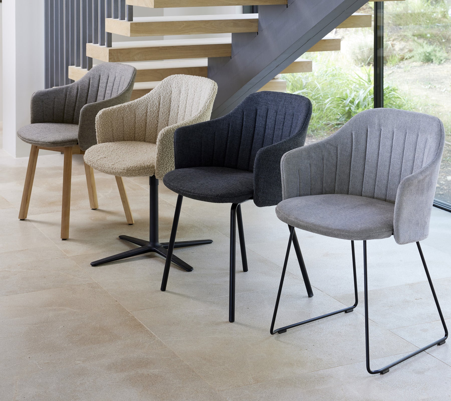 Quatre chaises modernes de différentes couleurs et styles présentées dans un cadre contemporain, mettant en valeur leurs designs uniques.