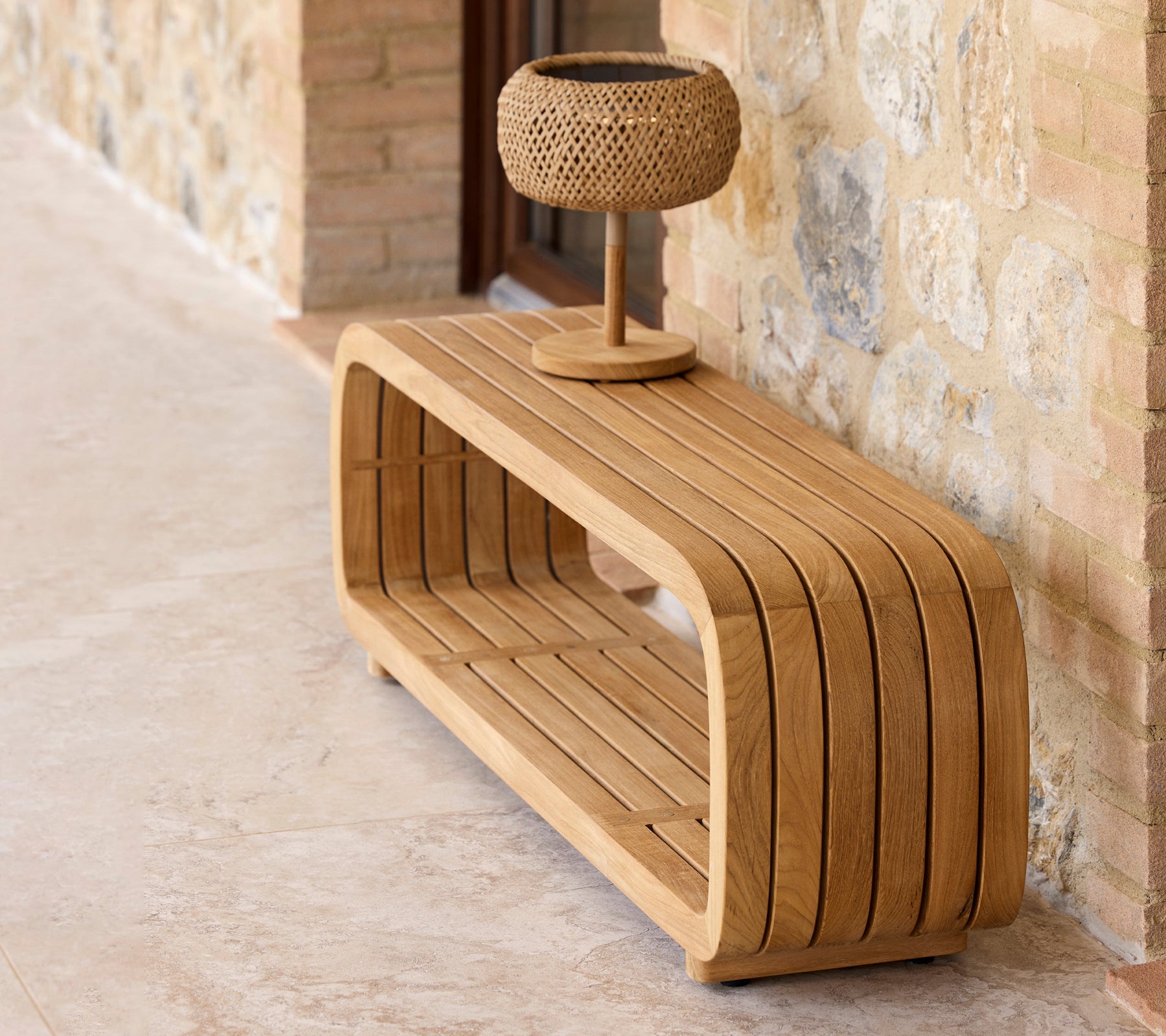 Une table basse en bois élégante avec un design courbé, dotée d'une petite lampe décorative sur le dessus.