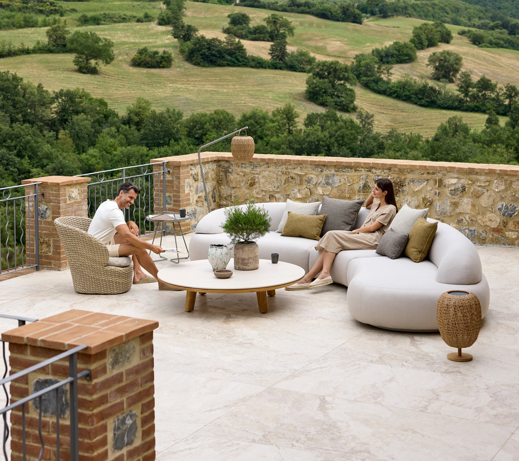 Arrangement de sièges relaxants avec un canapé lounge doux, un fauteuil Coast, une table basse Aspect et des accents Illusion Glow avec un arrière-plan pittoresque.