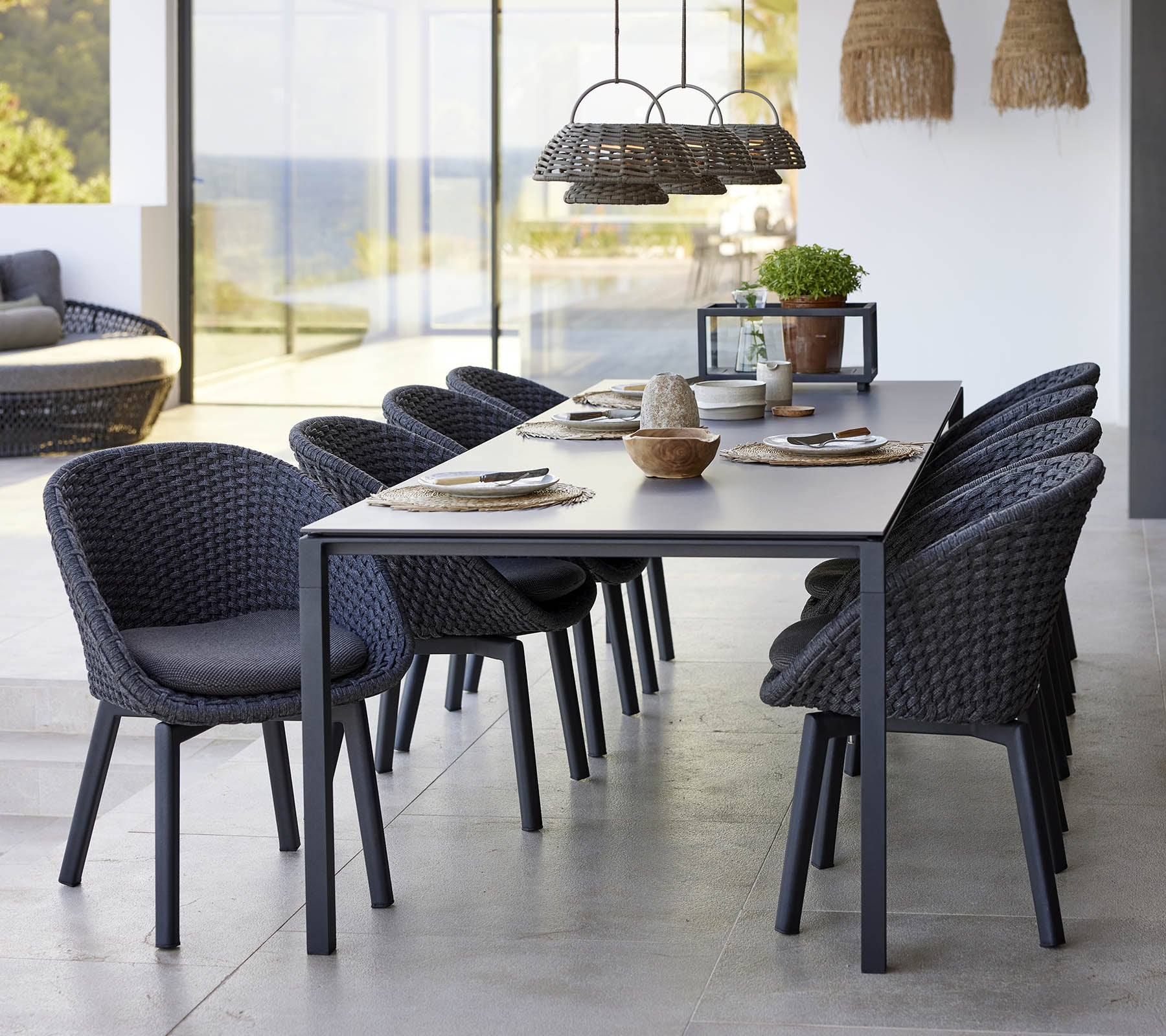 Une configuration de salle à manger élégante avec une table à manger pure, des chaises paon et une lampe d'illusion, améliorant une esthétique moderne.