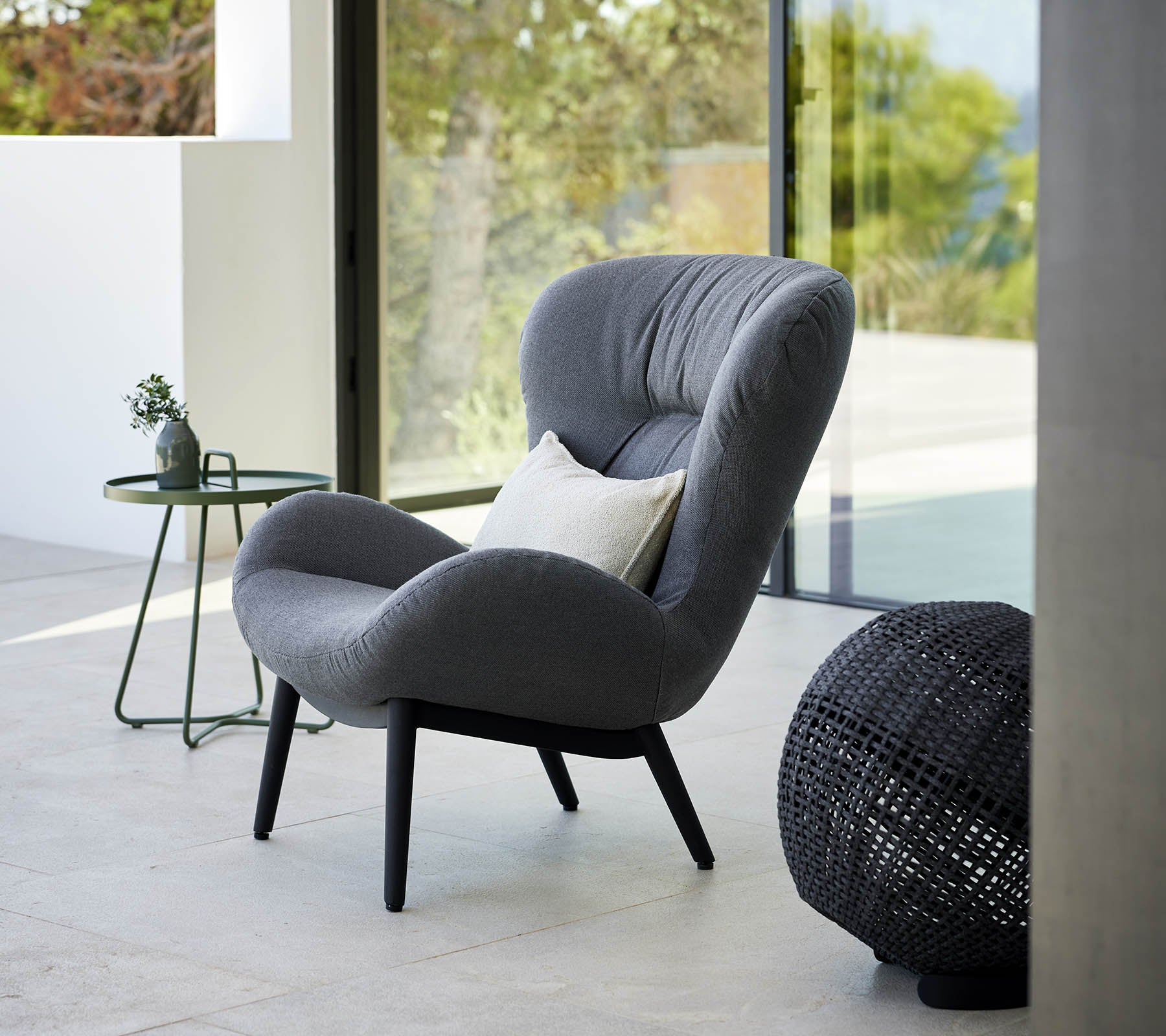 un fauteuil serein au design moderne, avec un rembourrage doux et des pieds élégants, accompagné d'une petite table d'appoint et d'accents décoratifs.