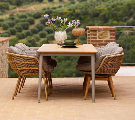 Aménagement de salle à manger chic avec une table à manger Core et des chaises Stay, ornée d'un vase de fleurs, créant une atmosphère accueillante.