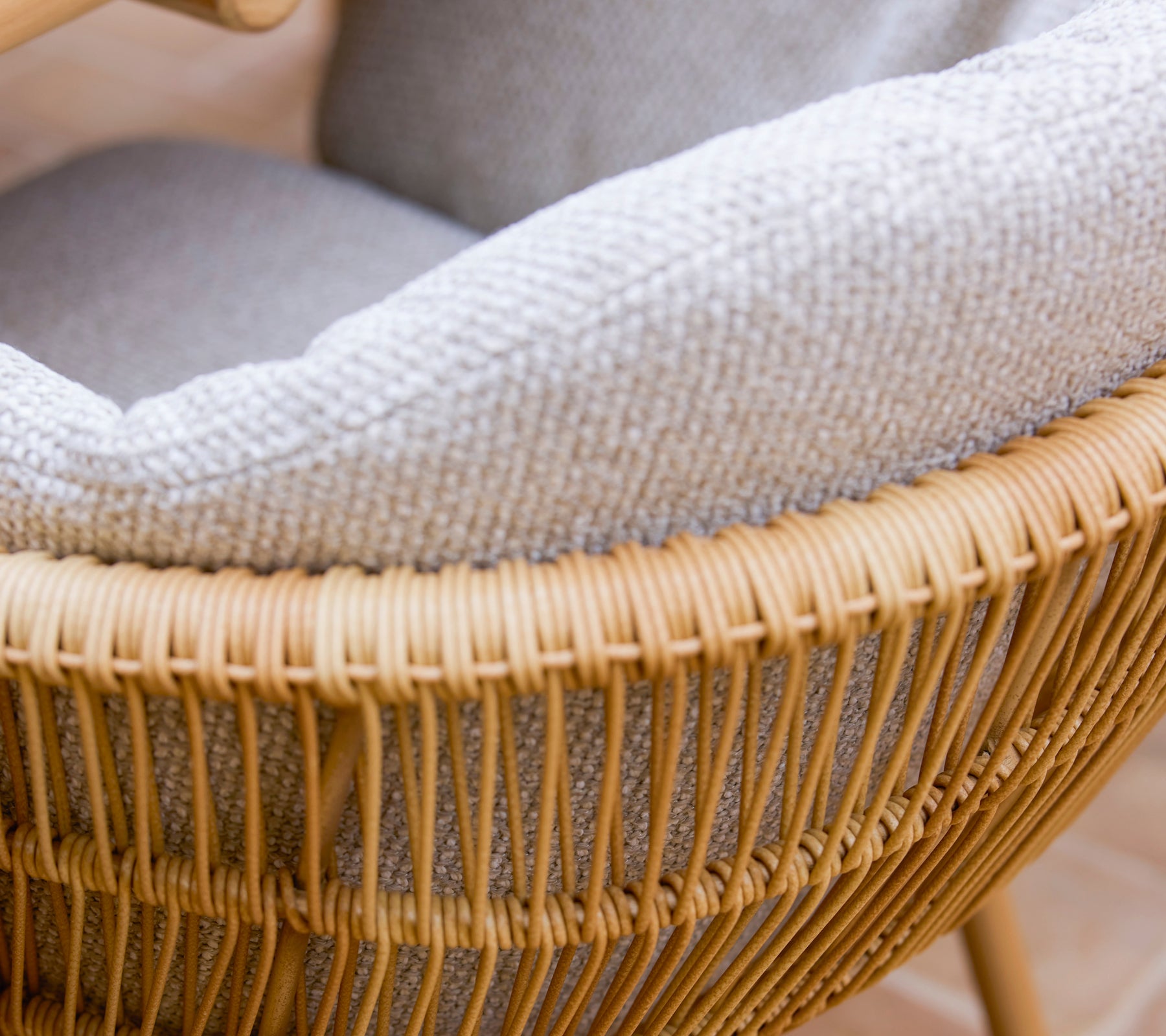 Chaise de salle à manger élégante avec un design tressé, des pieds en aluminium et un coussin Rice gris confortable.