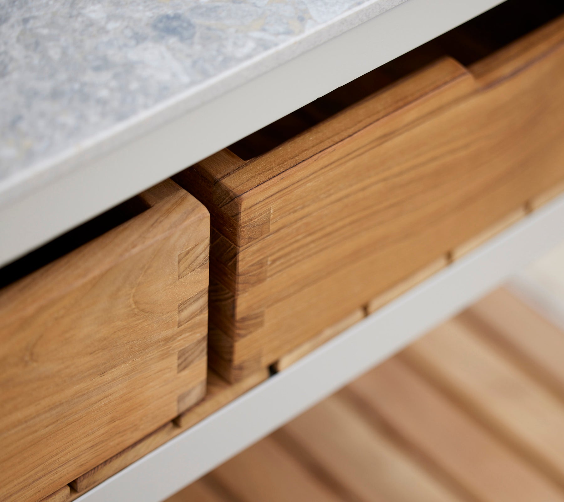 Des boîtes en teck avec une surface lisse, soigneusement rangées et organisées, mettant en valeur l'artisanat et le grain naturel du bois.