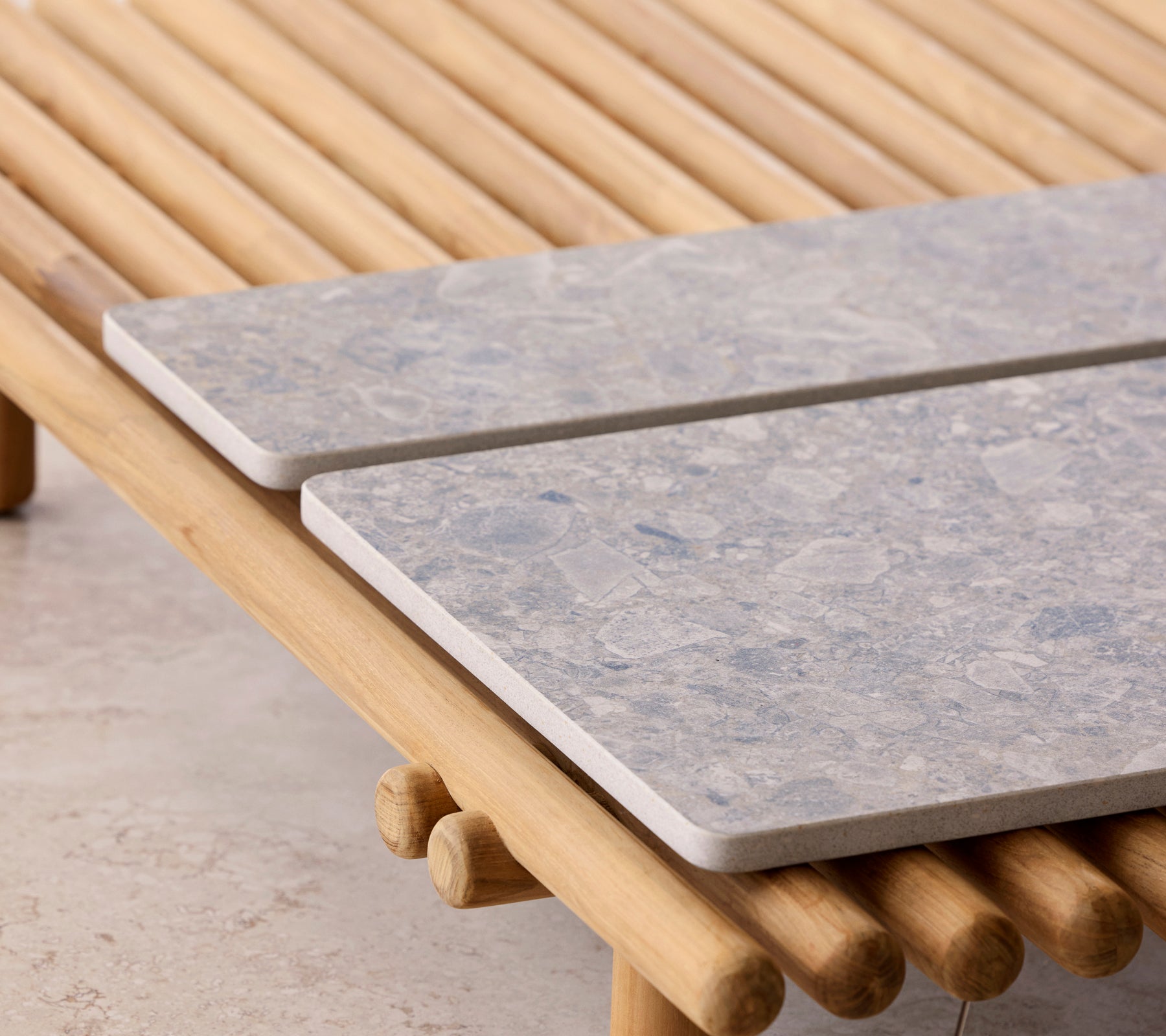 Une table basse avec un design en tige et deux plateaux en pierre reposant dessus.