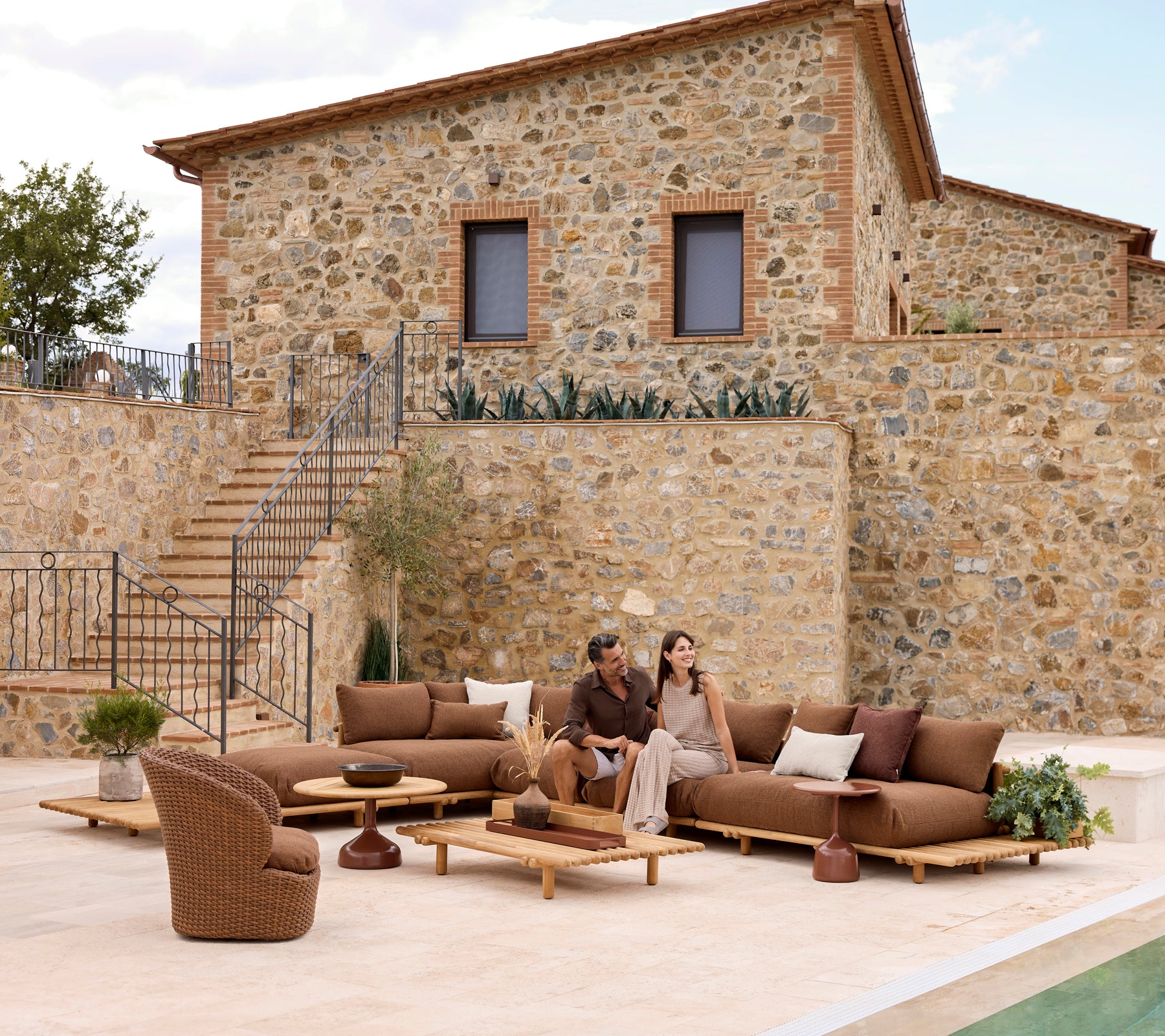 Espace lounge élégant avec des meubles en teck et des sièges confortables, idéal pour se détendre avec quelqu'un de spécial.