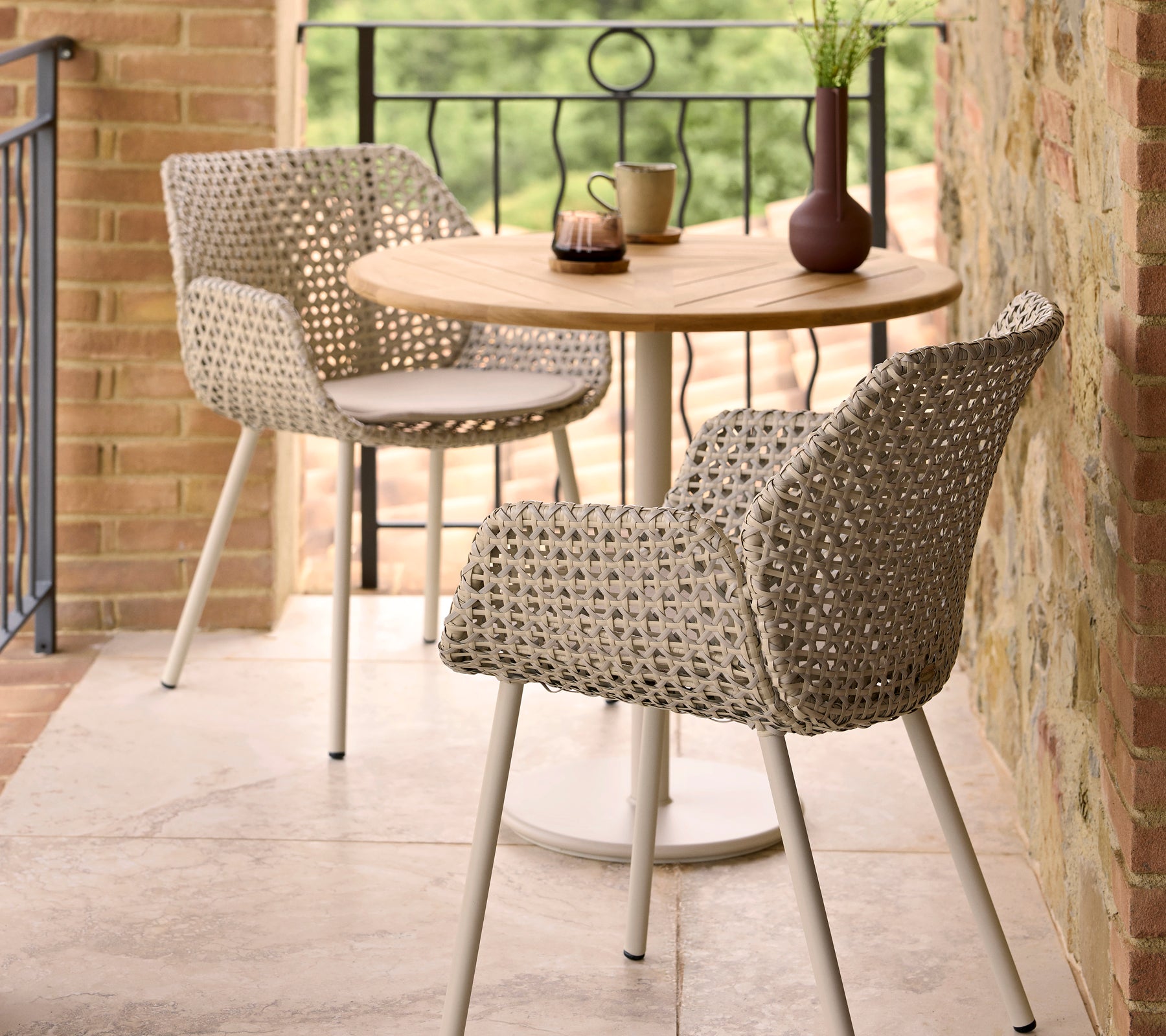 Chaises de dining Vibe élégantes associées à une table ronde Go café, complétées par des éléments décoratifs sur la table.